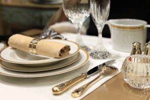 A table setting of fine china and crystal with beige linens